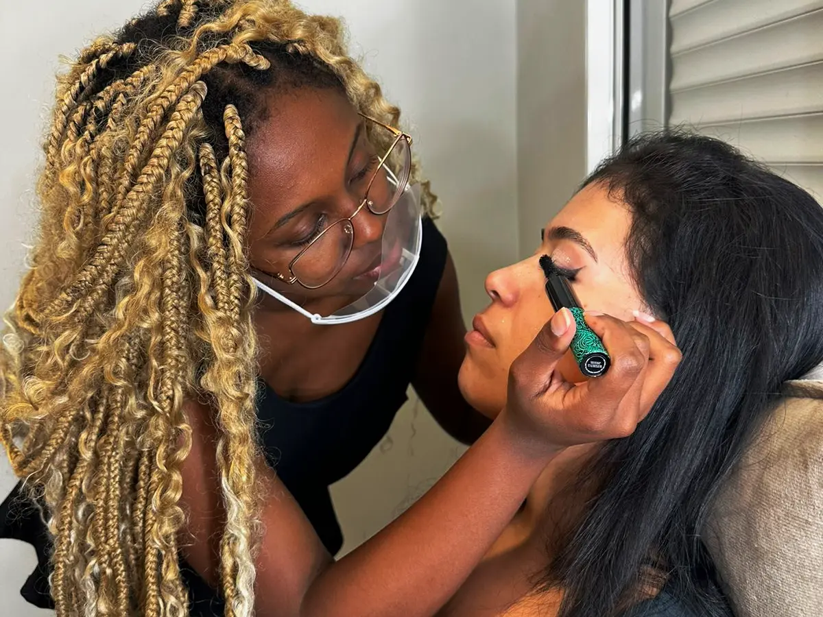 Laura aplicando maquiagem com precisão em atendimento a domicílio